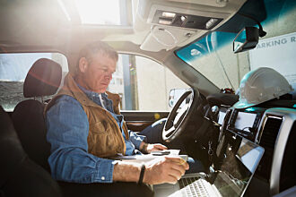 Cnstruction worker using laptop in truck